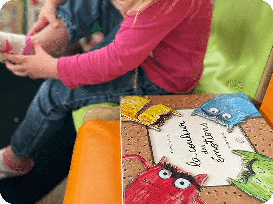 Petite fille assise à côté du livre les couleurs des émotions